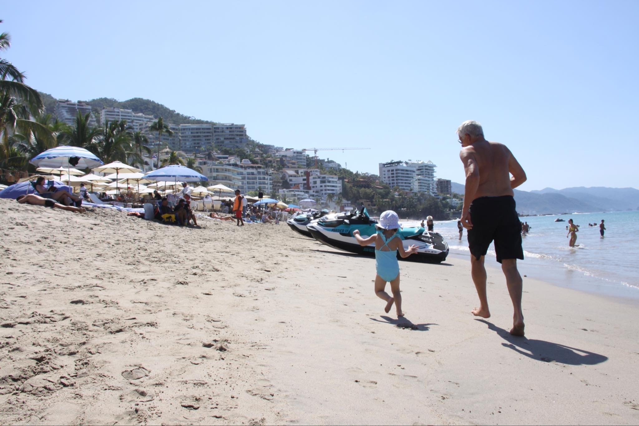 a man and a child running on a beach